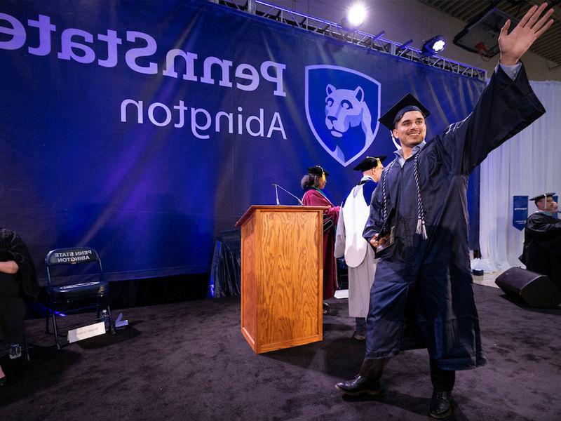 Student waves after accepting bachelor's degree