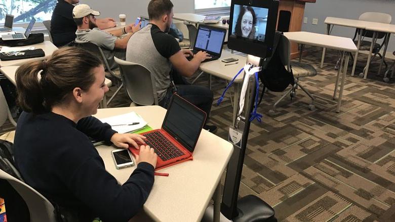 Students in class interact with robot
